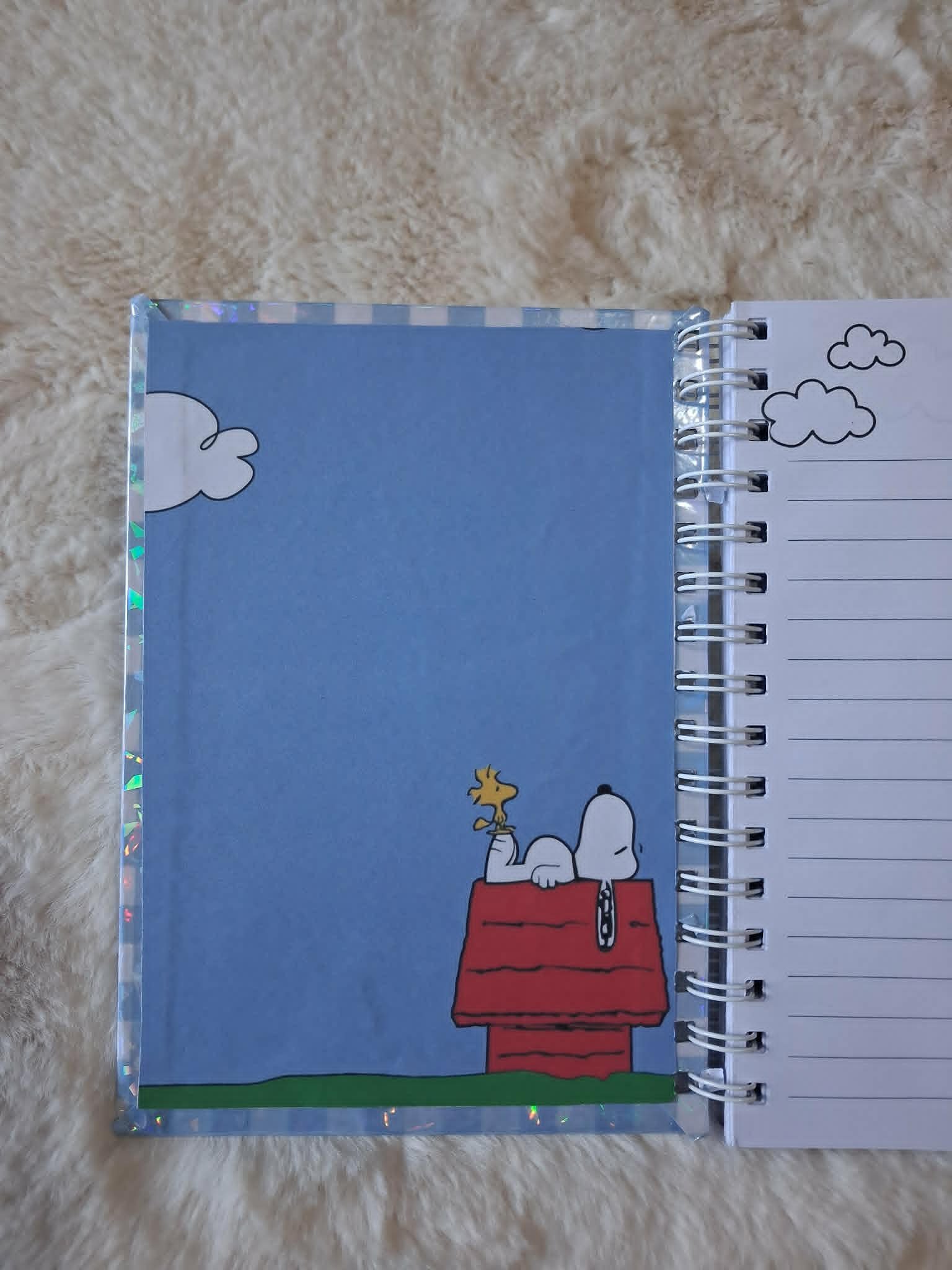 Carnet de notes Snoopy avec couverture holographique et reliure métallique.