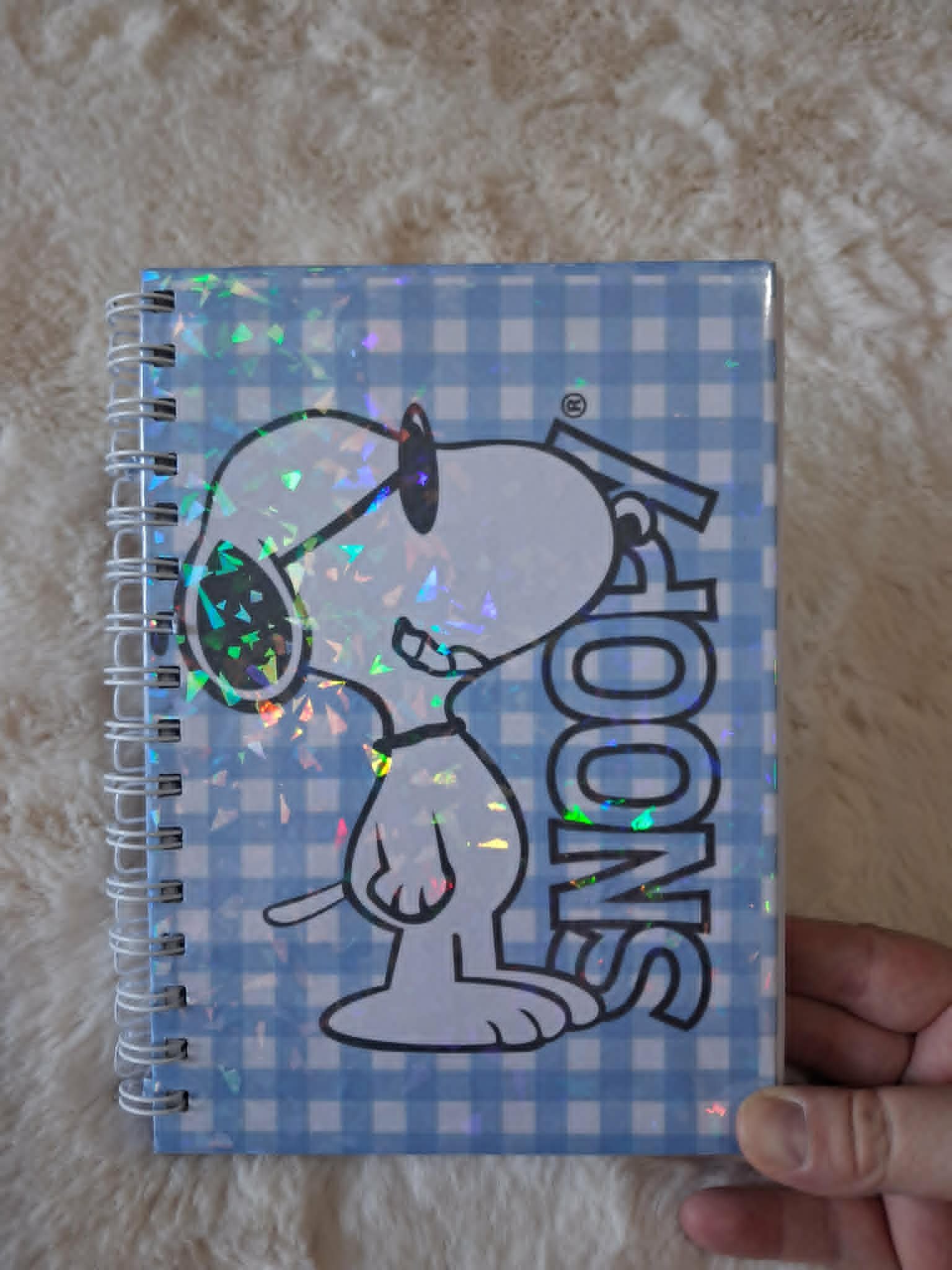 Carnet de notes Snoopy avec couverture holographique et reliure métallique.